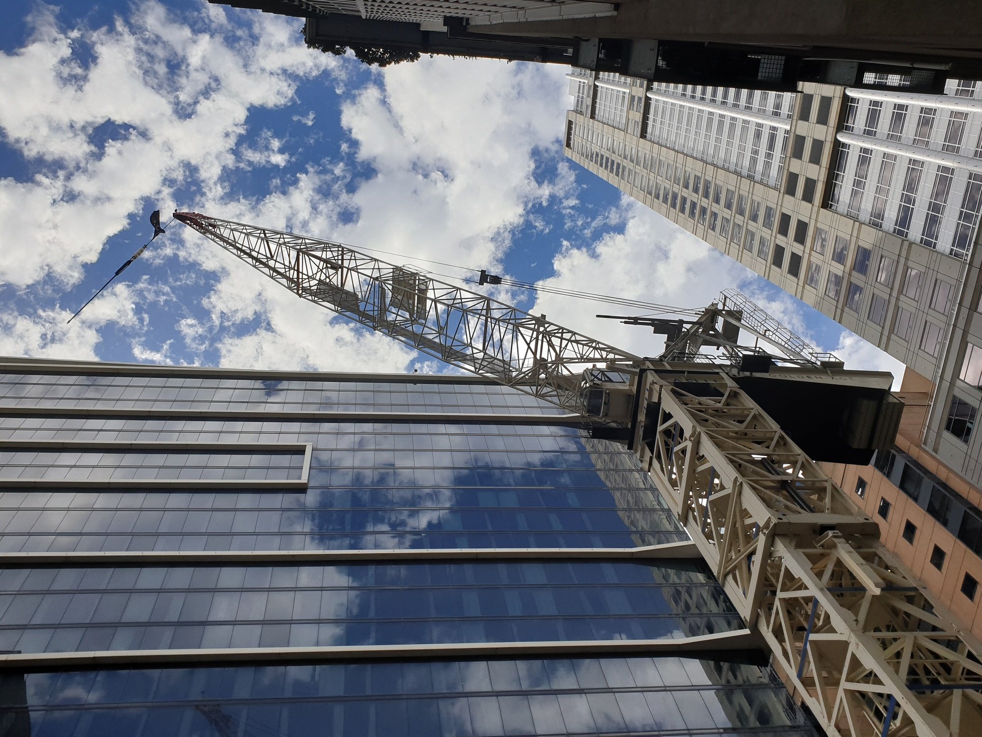 View of Cranes and building construction heavy equipment on site. Construction ongoing